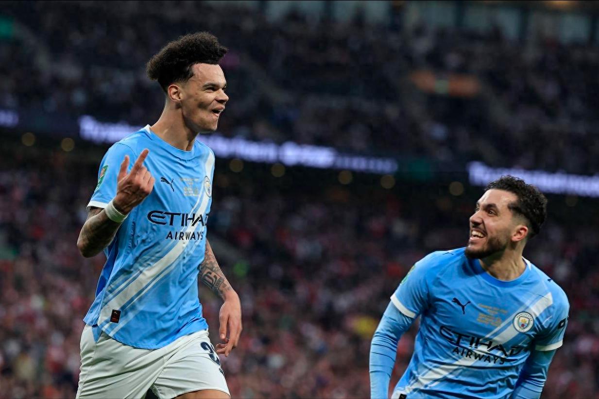 Manchester City's rising star scores twice with headers, backup goalkeeper secures clean sheet, 2-0 victory over Arsenal wins League Cup, Guardiola sets new record.